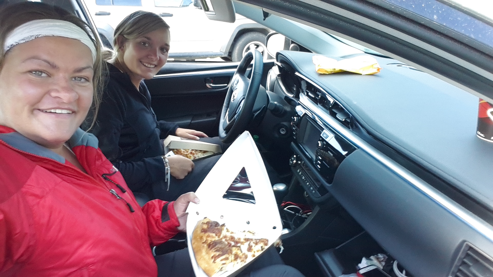 photograph of us eating pizza in the car on our American road trip