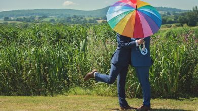 Gay couple under rainbow umbrella