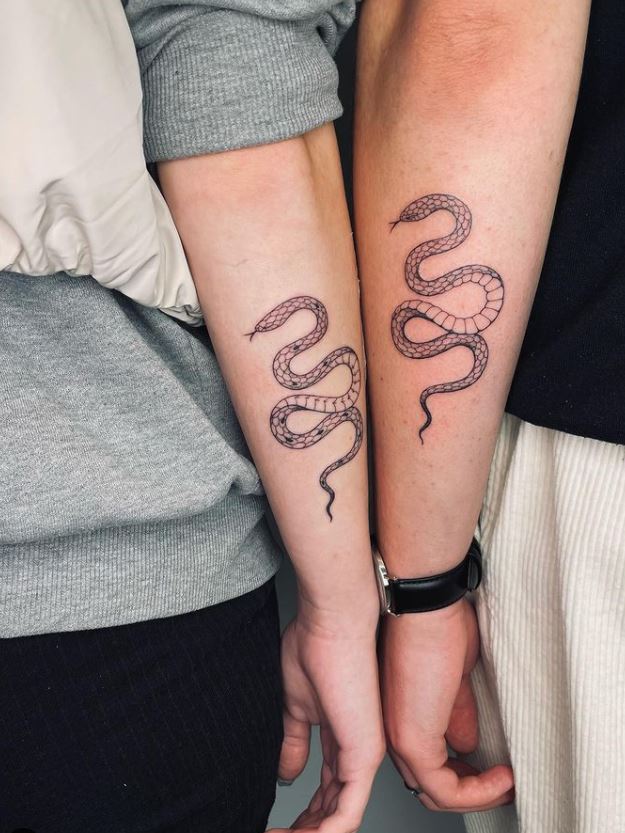 matching couple snake arm tattoo