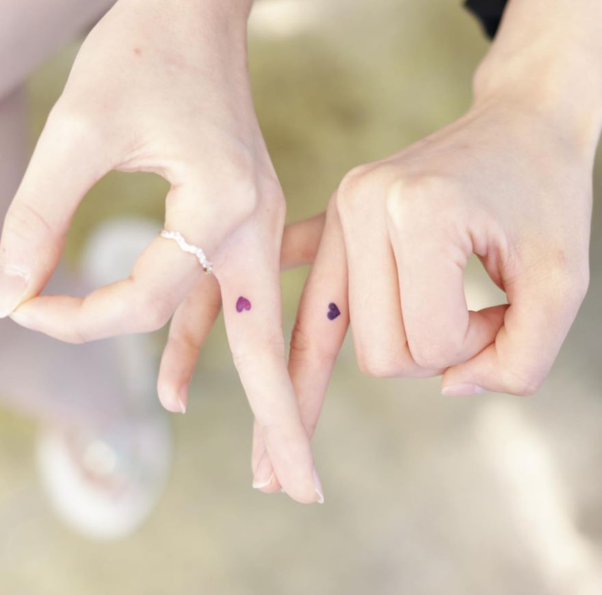 matching finger tattoos hearts couple